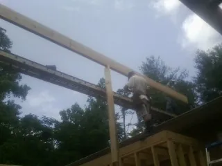 Carpenter setting a ridge beam over a new addition frame — Ice Dam Removal by Roofing Brothers in Thorp